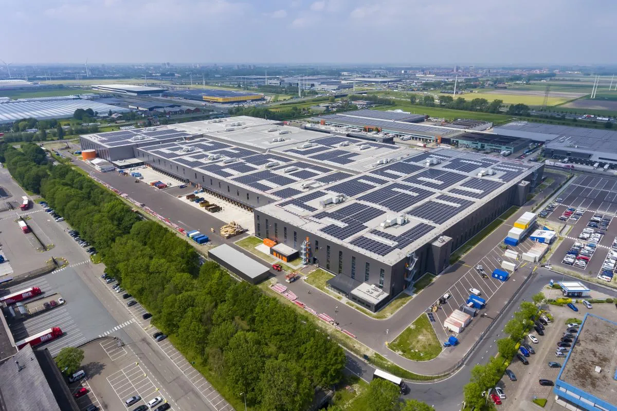 Aerial view of industrial warehouse with solar panels.